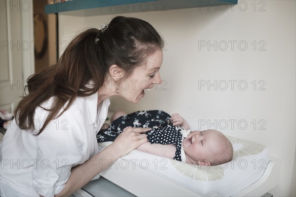 Mother playing with baby daughter (2-5 months).