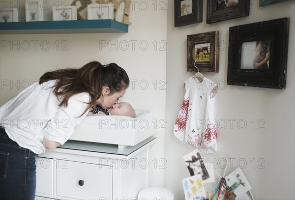 Mother kissing baby daughter (2-5 months).