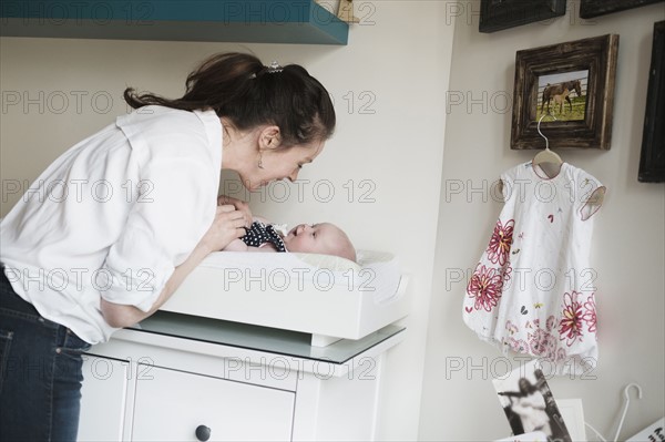 Mother playing with baby daughter (2-5 months).