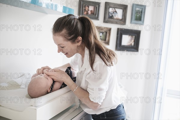 Mother playing with baby daughter (2-5 month).