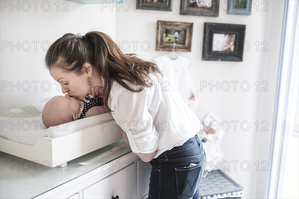 Mother kissing baby daughter (2-5 months).