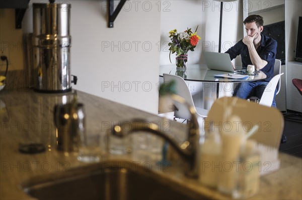 Man working on laptop at home.