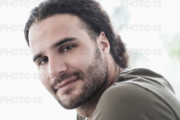 Portrait of young man with long curly hair.