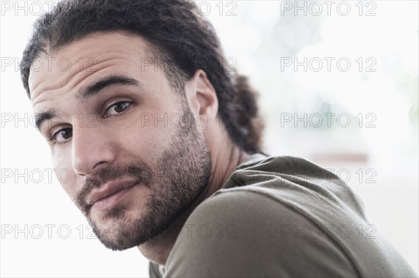 Portrait of young man with long curly hair.