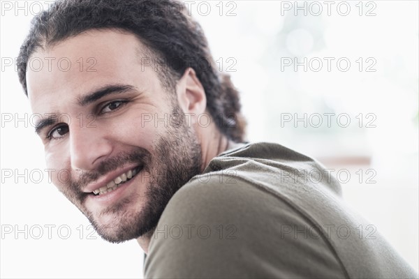 Portrait of young man with long curly hair.