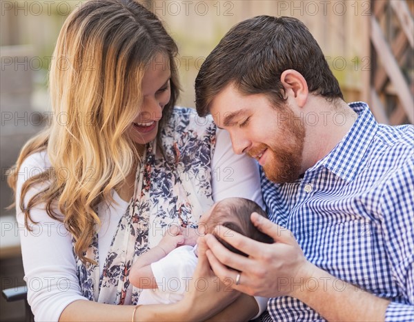 Happy parents holding girl (2-5 months)