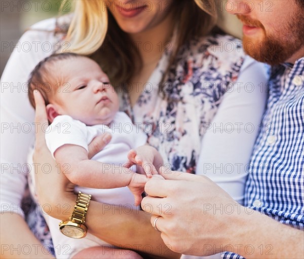 Happy parents holding girl (2-5 months)