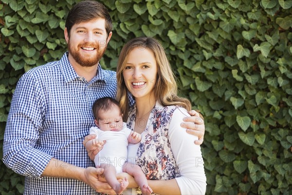 Happy parents holding girl (2-5 months)