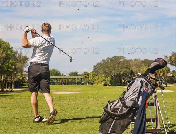 Mid adult man playing golf