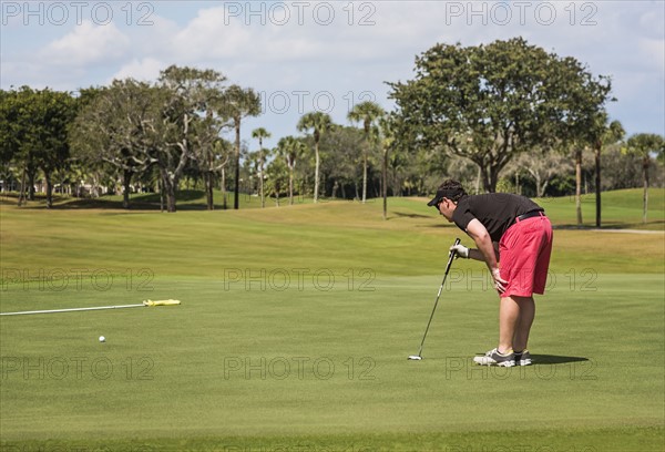 Mid adult man playing golf