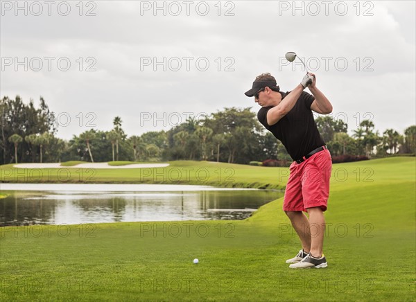 Mid adult man playing golf
