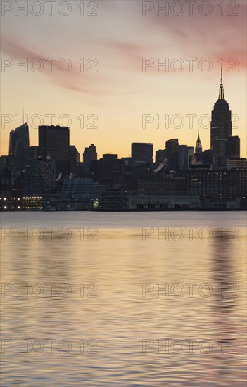 Waterfront with city skyline at dawn