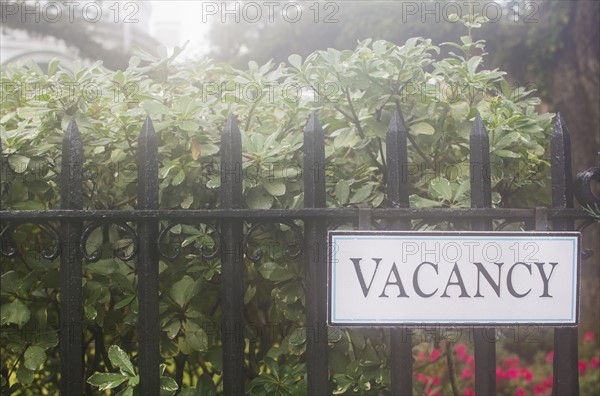 Vacancy sign on hotel's fence