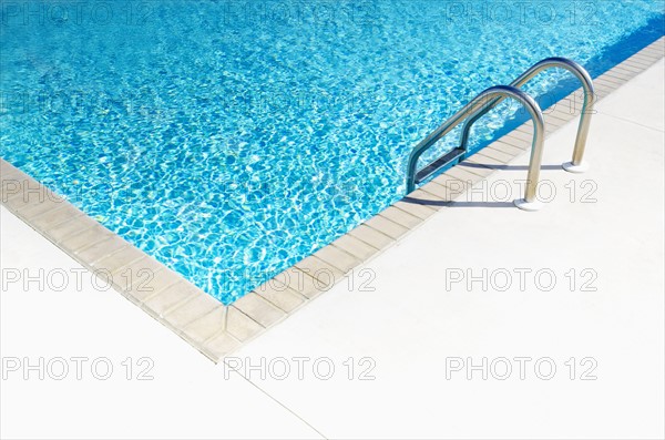 Edge of empty swimming pool in sunlight