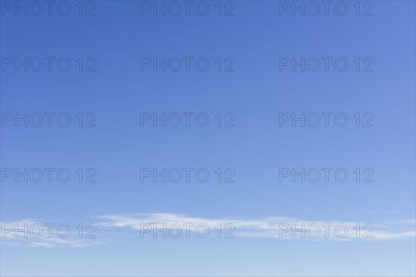 Clear blue sky with scattered clouds