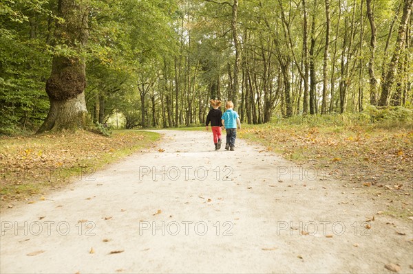 Children (2-3,4-5) walking in park