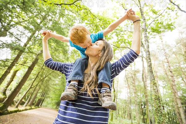 Mother carrying on shoulders son (2-3)