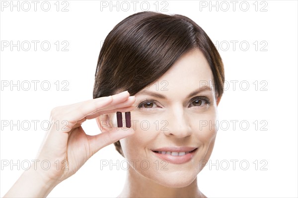 Portrait of beautiful woman holding capsules