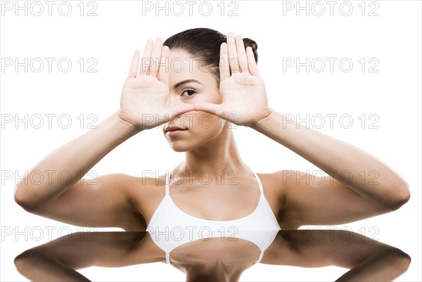 Young woman with hands in front of face