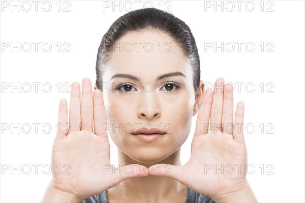 Young woman with hands in front of face