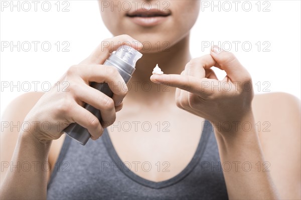 Young woman applying moisturizer