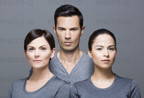 Man and two women wearing grey tops