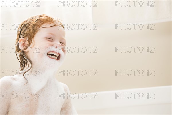 Smiling girl (4-5) having bubble bath