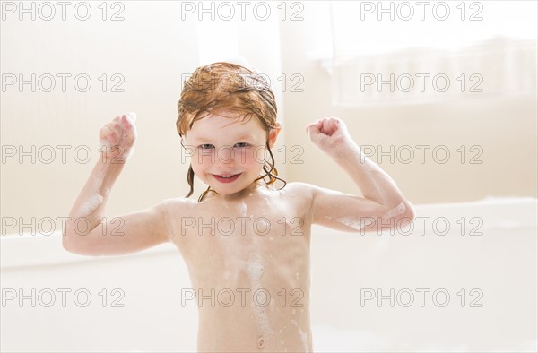 Smiling girl (4-5) having bubble bath