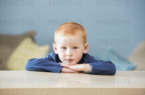 Little boy (2-3) leaning on table