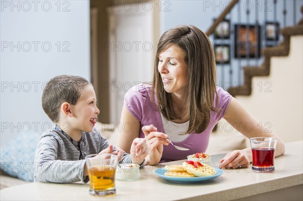 Mother and son (6-7) eating breakfast
