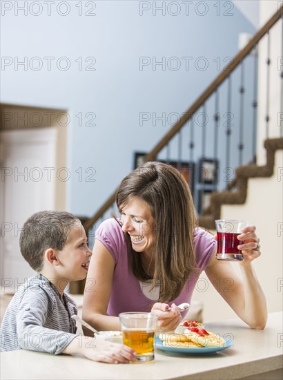 Mother and son (6-7) eating breakfast