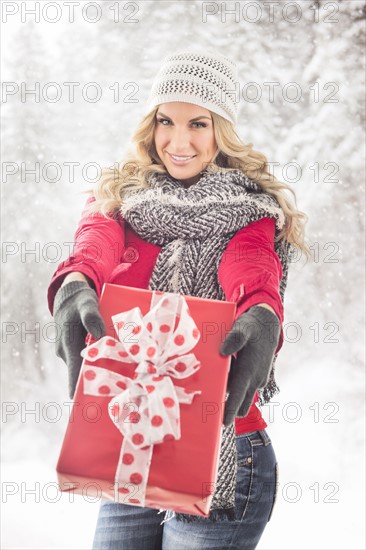 Portrait of young woman holding Christmas present