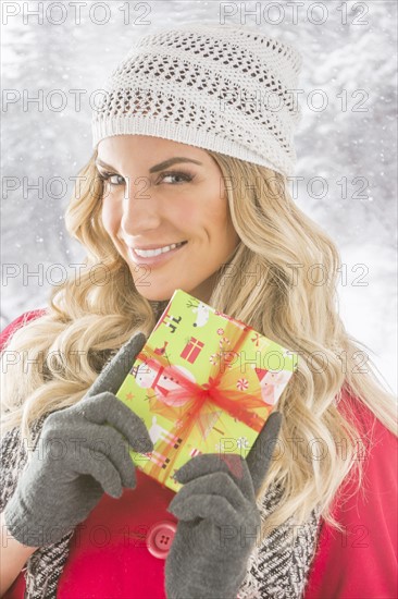 Portrait of young woman holding Christmas present