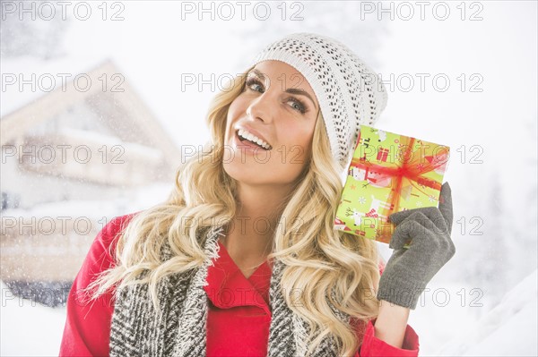 Portrait of young woman holding Christmas present