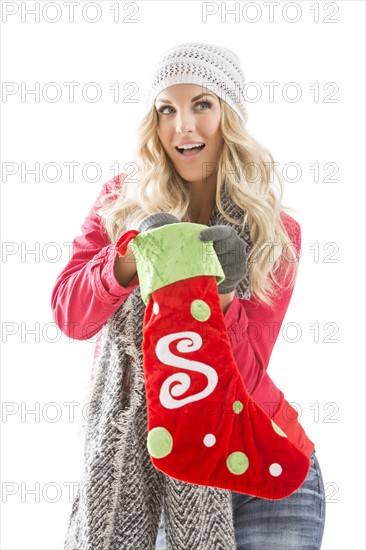 Portrait of young woman holding Christmas stocking