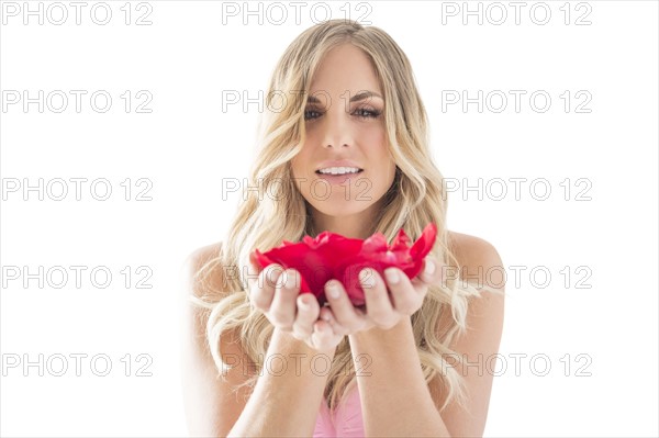 Young woman holding rose petals in hands