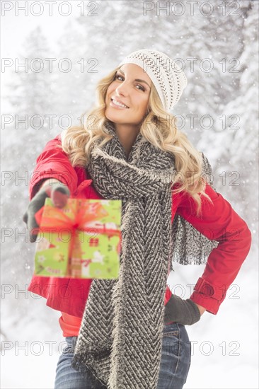 Portrait of young woman holding Christmas present