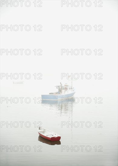 Boats in fog floating on water