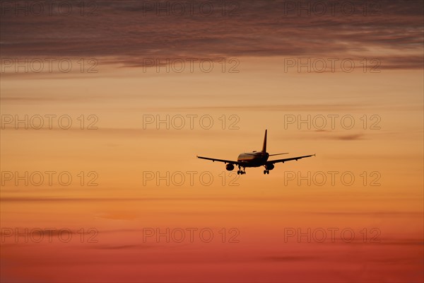 Airplane against orange sky