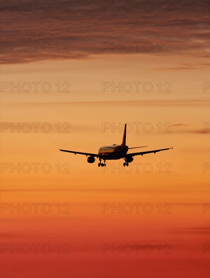 Airplane against orange sky