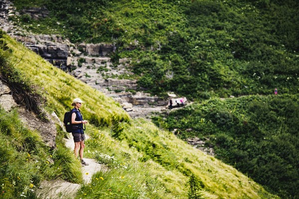 Mature woman standing on path in mountains