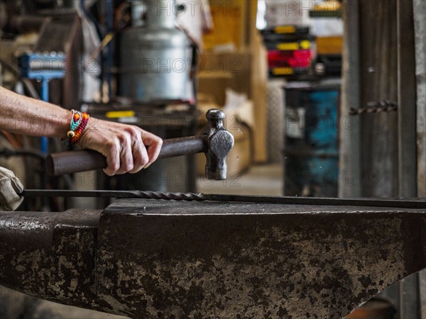 Close up of hand of female blacksmith at work