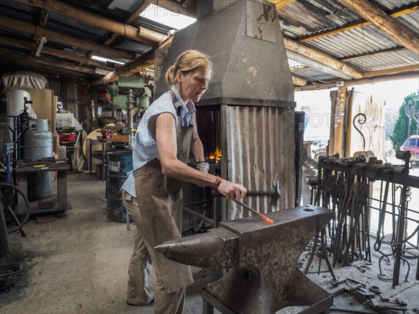 Female blacksmith working in workshop