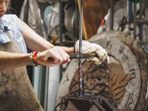 Female blacksmith working in workshop