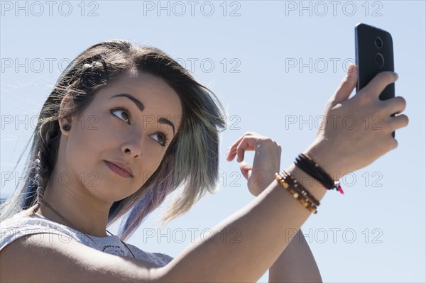 Young woman holding mobile phone.