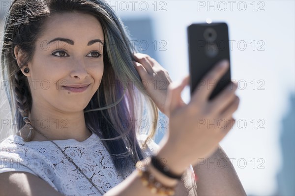 Young woman holding mobile phone.