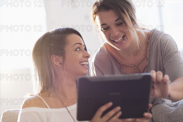 Young women using digital table at home.