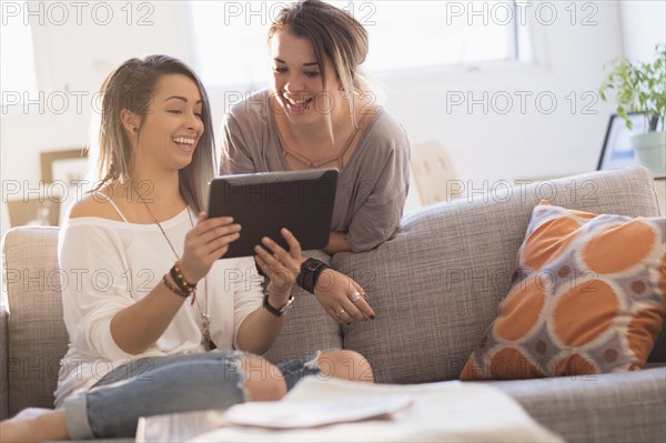 Young women using digital table at home.