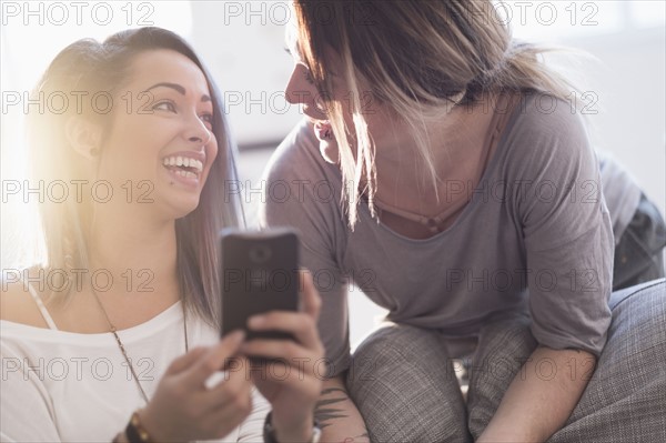 Young women using mobile phone at home.