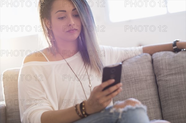 Young woman holding mobile phone.